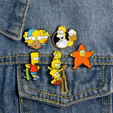 Dettaglio di cinque spille smaltate a cartone animato su tasca di jeans blu