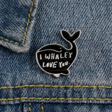 Dettaglio della spilla a balena smaltata con scritta I WHALEY LOVE YOU su denim
