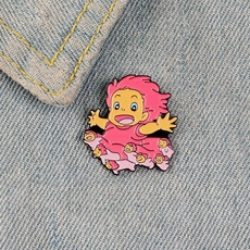 Close-up of a Ponyo enamel pin accessory on blue denim background for backpacks
