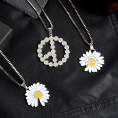 Detailed macro view of daisy enamel pendants with peace sign and lightning motifs