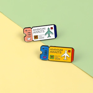 Detail of colorful enamel boarding pass pins with Adventure Awaits text and plane icons