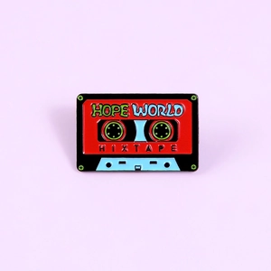 Détail de l'épingle en émail vintage en forme de cassette avec texte Hope World