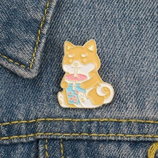 Detail of Shiba Inu enamel pin with bubble tea fixed on blue denim jacket fabric