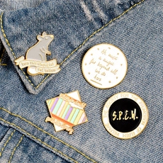 Macro shot of Harry Potter enamel pins set on a blue denim jacket with S.P.E.W. and Scabbers themes