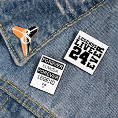 Close-up of Kobe Bryant themed enamel pins featuring Mamba logos on denim fabric