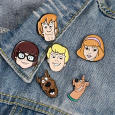 Detailed view of Scooby-Doo enamel pins collection pinned on a blue denim jacket collar