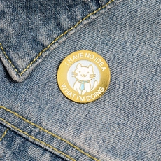 Close-up of Grape Soda cat enamel pin on denim jacket with I HAVE NO IDEA text