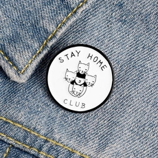 Detail of Stay Home Club cat enamel pin on blue denim fabric background textures