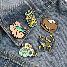 Macro detail of five cute cartoon cat enamel pins pinned on a blue denim jacket collar