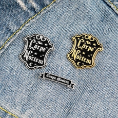 Detail of Carpe Noctem gothic enamel pins on blue denim fabric with moon and stars