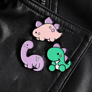 Lot de trois broches en émail dinosaure de dessin animé sur une veste en cuir noir