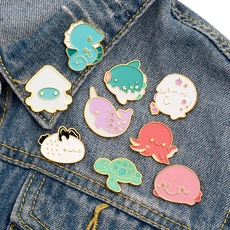 Detailed close-up of colorful cartoon sea creature enamel pins on blue denim jacket