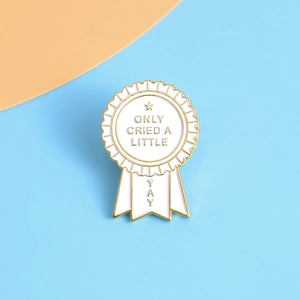 Detailed macro of enamel award medal pin with ONLY CRIED A LITTLE funny slogan