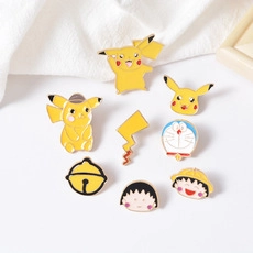 Macro view showing a collection of colorful enamel pins of cartoon characters on white cloth