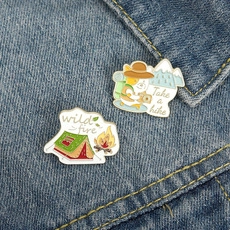 Detail of outdoor camping enamel pins with corgi and tent on denim jacket background