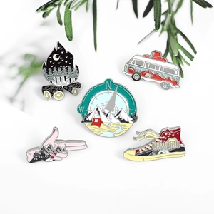 Detailed set of outdoor camping enamel pins featuring forest scenery and canvas shoes