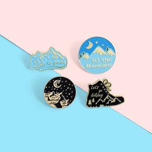 Close-up of hiking boots and mountain adventure enamel pins for outdoor travel