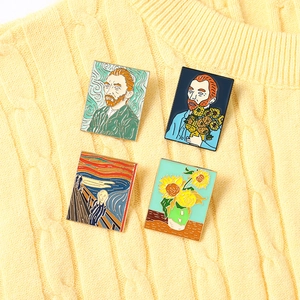 Detailed macro view of four artistic Van Gogh enamel pins on a yellow knit sweater