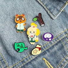 Close-up of Animal Crossing enamel pins featuring Tom Nook and Isabelle on blue denim