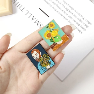Artistic Van Gogh sunflower and self-portrait enamel brooches held by hand
