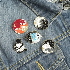 Set of 5 enamel pins with cat and moon art on a blue denim jacket pocket