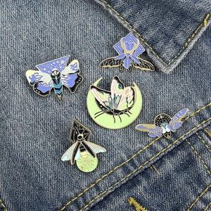 Lot de cinq broches émaillées en forme d'insectes, papillons et mites sur tissu en denim