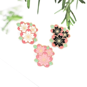 Exquisite cherry blossom enamel pins set with gold metal edges and floral details
