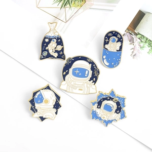Detail of 5-piece enamel astronaut brooch set with blue and gold drip oil finish