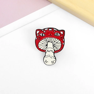 Close-up of a creative red mushroom cat enamel pin with polished alloy finish