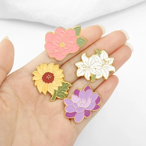 Set of four floral enamel pins featuring lily, sunflower, camellia and lotus designs