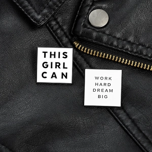Detail of square enamel pins with Work Hard Dream Big and This Girl Can slogans