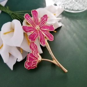 Detail view of pink enamel flower brooch with gold base and elegant lily petals