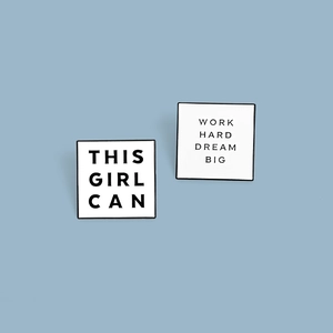Macro detail of square enamel badges with motivational Work Hard and Dream Big slogans