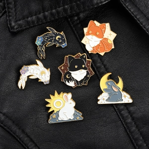 Detailed macro view of six enamel animal pins featuring koi fish and rabbits on a black jacket