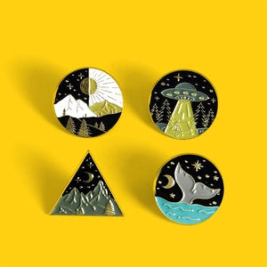 Set of four creative whale tail and nature landscape enamel pins on yellow background