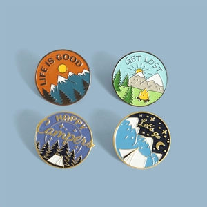 Detailed set of four round enamel pins featuring outdoor camping and mountain scenery