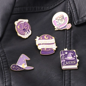 Detail of 5-piece purple magic enamel pins featuring wizard hats and spell books on leather