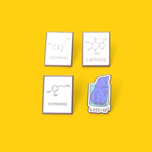 Set di spille smaltate con strutture chimiche di serotonina, caffeina e dopamina