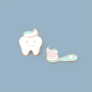 Detail of enamel tooth and toothbrush pins with cute expressions and gold metal edges