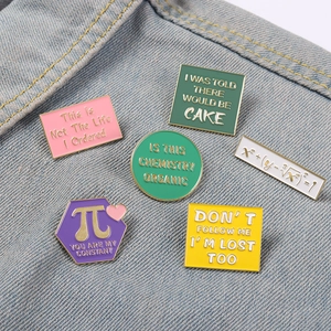 Detail of funny math and science enamel pins set on a denim background fabric