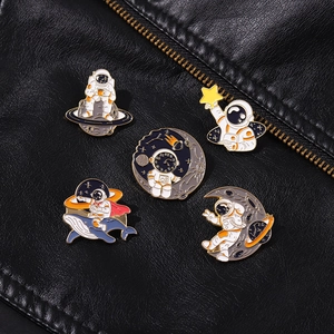 Detailed macro view of 5-piece astronaut and whale enamel brooch set on black leather jacket