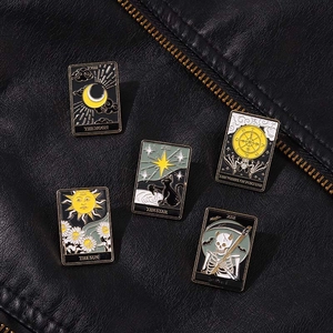 Détail de cinq pin's de tarot en émail style punk sur texture de veste en cuir noir