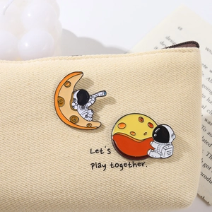 Detail von Astronauten und Mond Emaille Pins auf einer Stofftasche mit Text