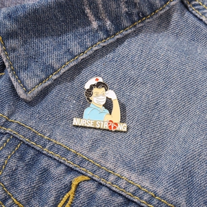 Detail of Nurse Strong enamel pin with muscle pose on blue denim jacket fabric