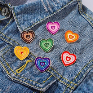 Detail of colorful enamel heart brooches pinned on high-quality denim fabric jacket