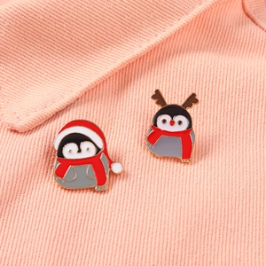 Détail de pin's pingouins de Noël en émail sur veste en jean rose avec bordure dorée