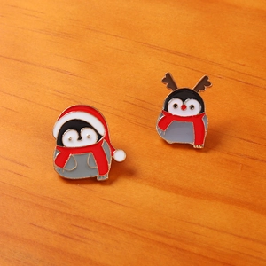 Détail de pins de pingouins de Noël en émail avec chapeaux et écharpes sur bois