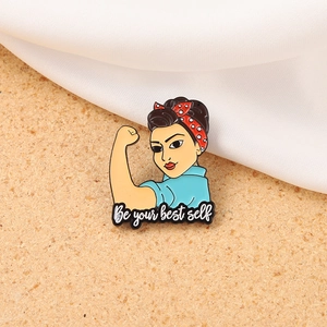 Enamel brooch with Rosie the Riveter style nurse and Be your best self quote on cork background