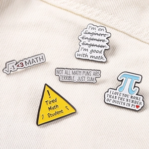 Close-up of five math enamel pins with Pi and Engineer puns on corduroy fabric