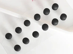 Set of 12 matte black round magnetic scarf clips displayed on transparent cards